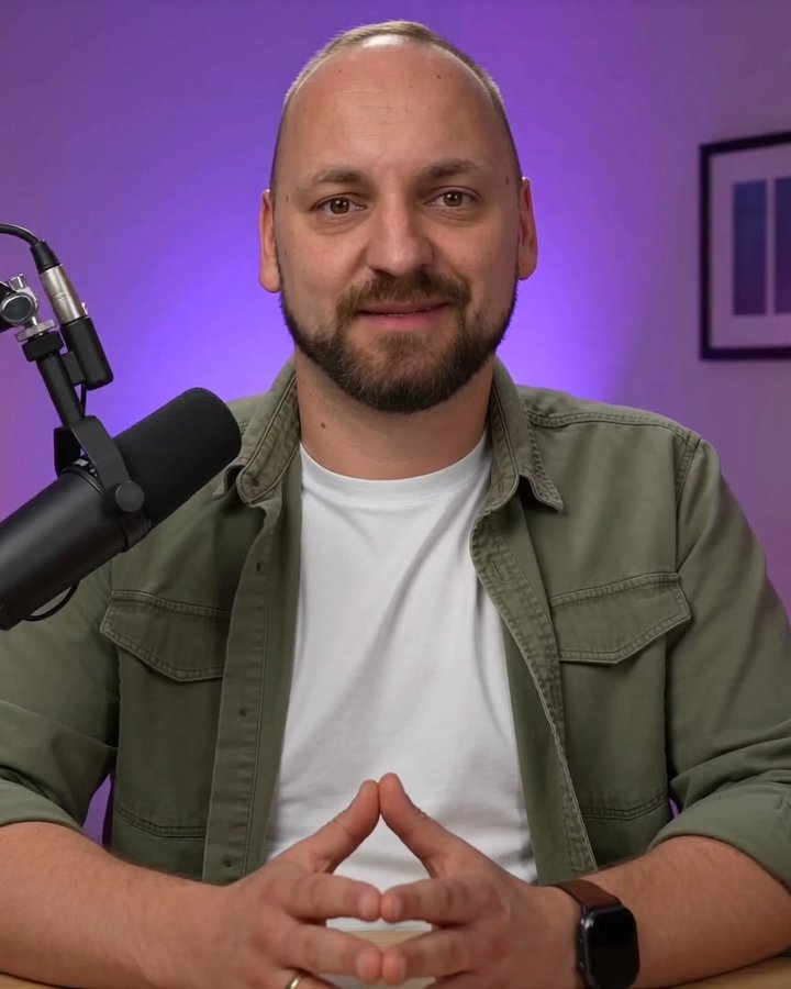 Damian Nowaczek przy biurku w studiu z mikrofonem, w którym nagrywa lekcje kursu