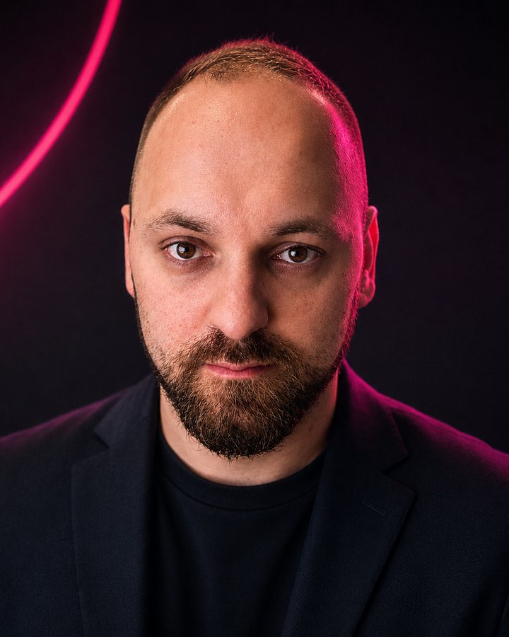 Portret Damiana Nowaczka na ciemnym tle z różowym neonem